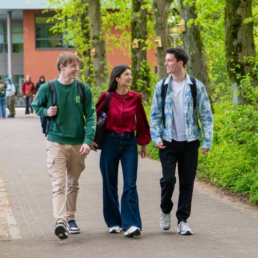 Drie studenten hbo Toegepaste Psychologie lopen buiten op de HAN campus in Nijmegen