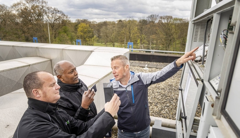Drie Vastgoedinspecteurs overleggen tijdens een inspectie.