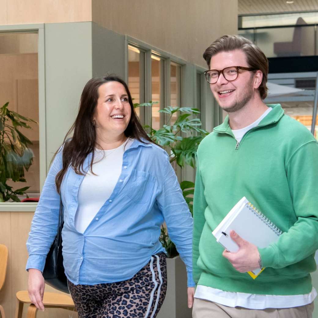 2 masterstudenten lopen op de gang