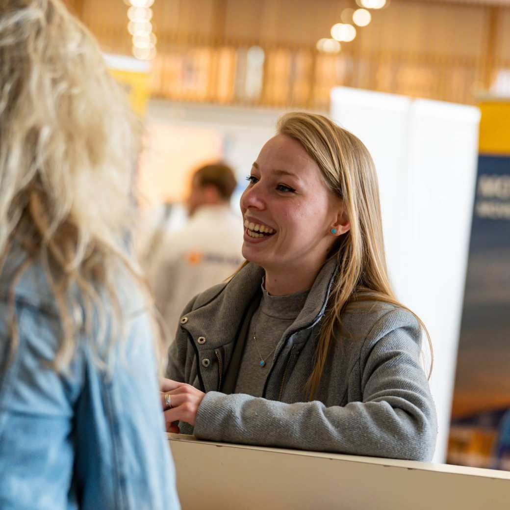 Foto van student die in gesprek is op een Netwerkmarkt.