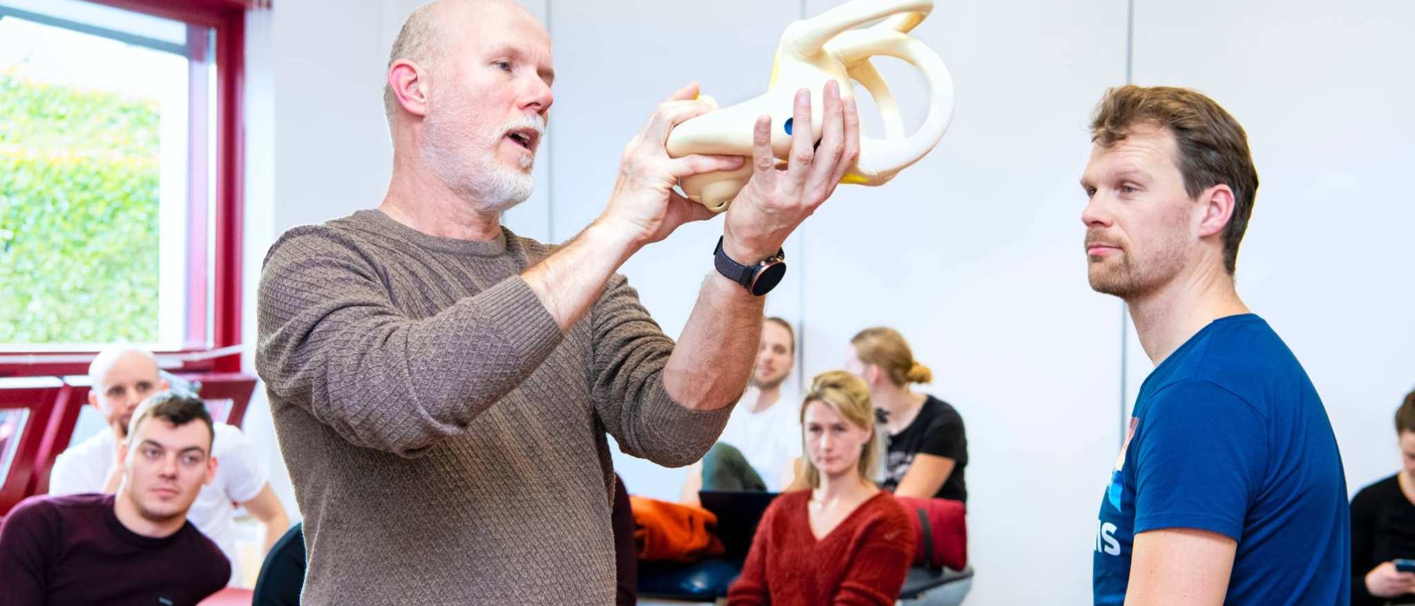 Docent legt met behulp van een anatomiemodel uit hoe een oor eruit ziet.