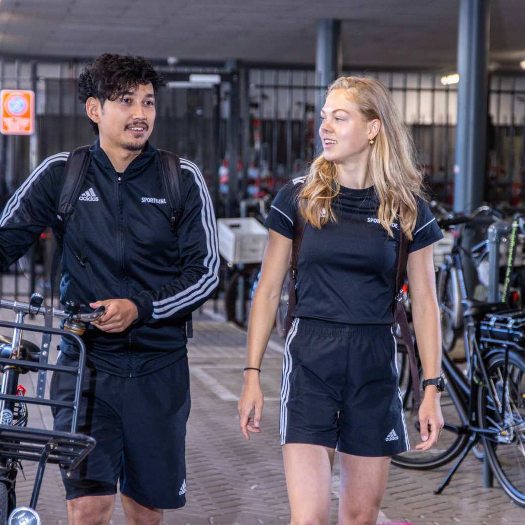 Studenten Sportkunde kletsen met elkaar in het fietsenhok