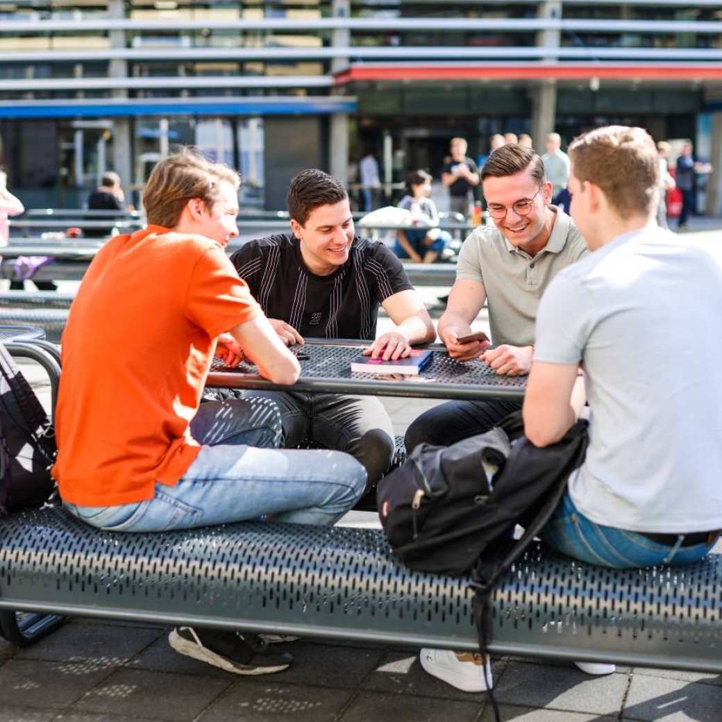 Logistics Management voltijd, foto 8383, studenten buiten aan tafel op het plein in Arnhem