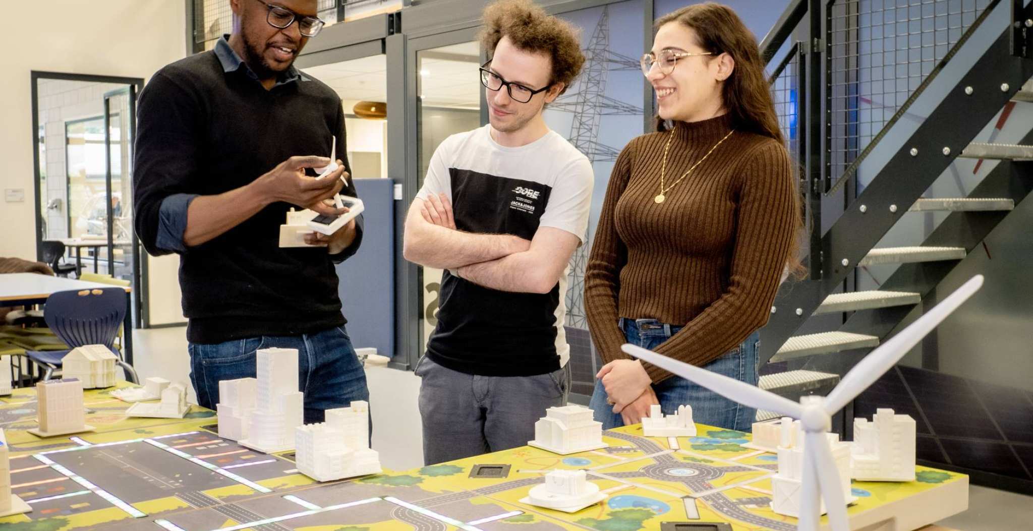 Studenten van de Master Engineering Systems Sustainable Energy en een docent bij de Smart Grid-tafel