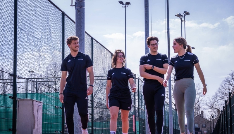 Sportkunde studenten wandelen langs de sportvelden bij HAN Sport en Bewegen