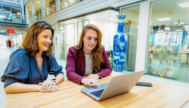 Twee studenten van de associate degree Bedrijfskunde zitten op hun laptop