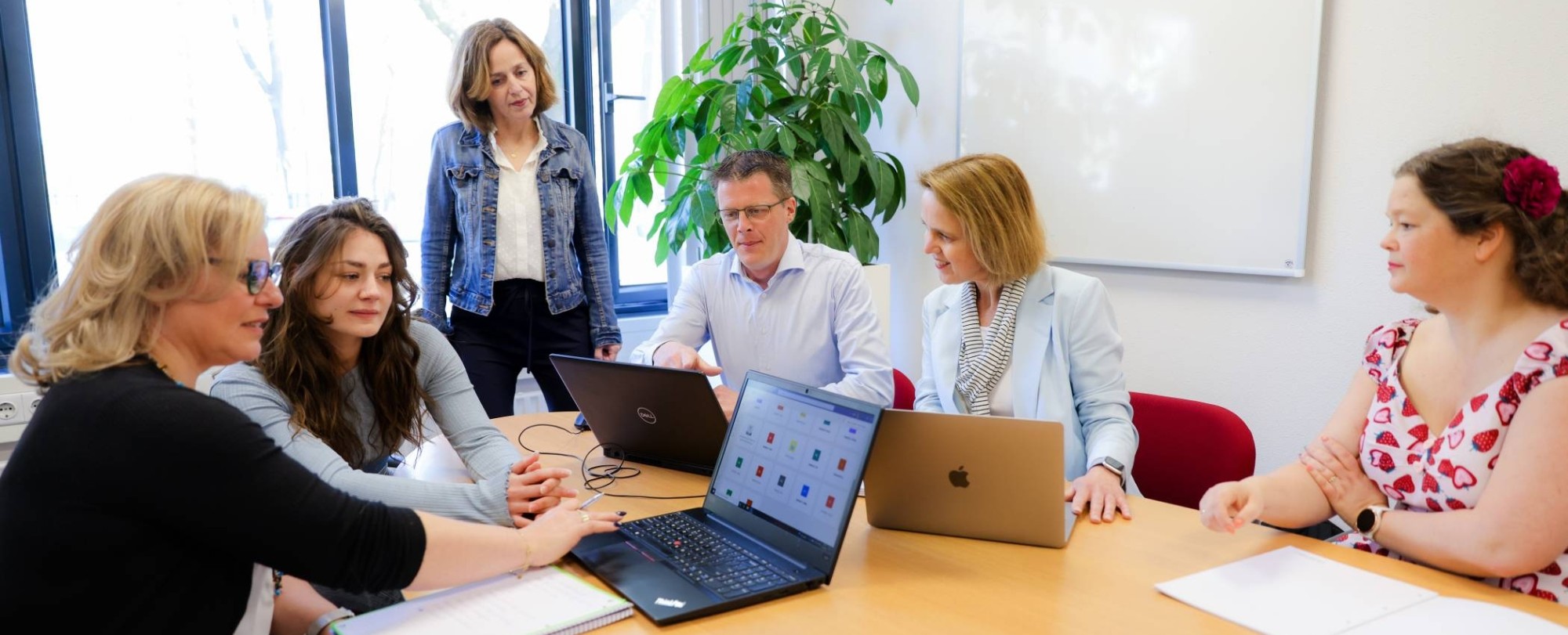 Deelnemers van Prince2 werken samen met een flipover met post-its