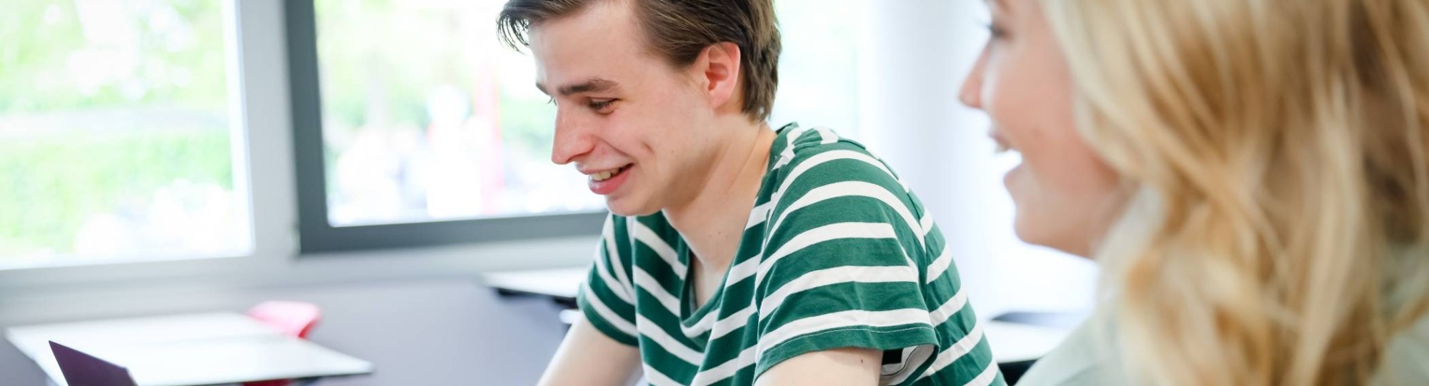 Twee studenten van hbo bedrijfskunde aan tafel tijdens een projectgroep overleg