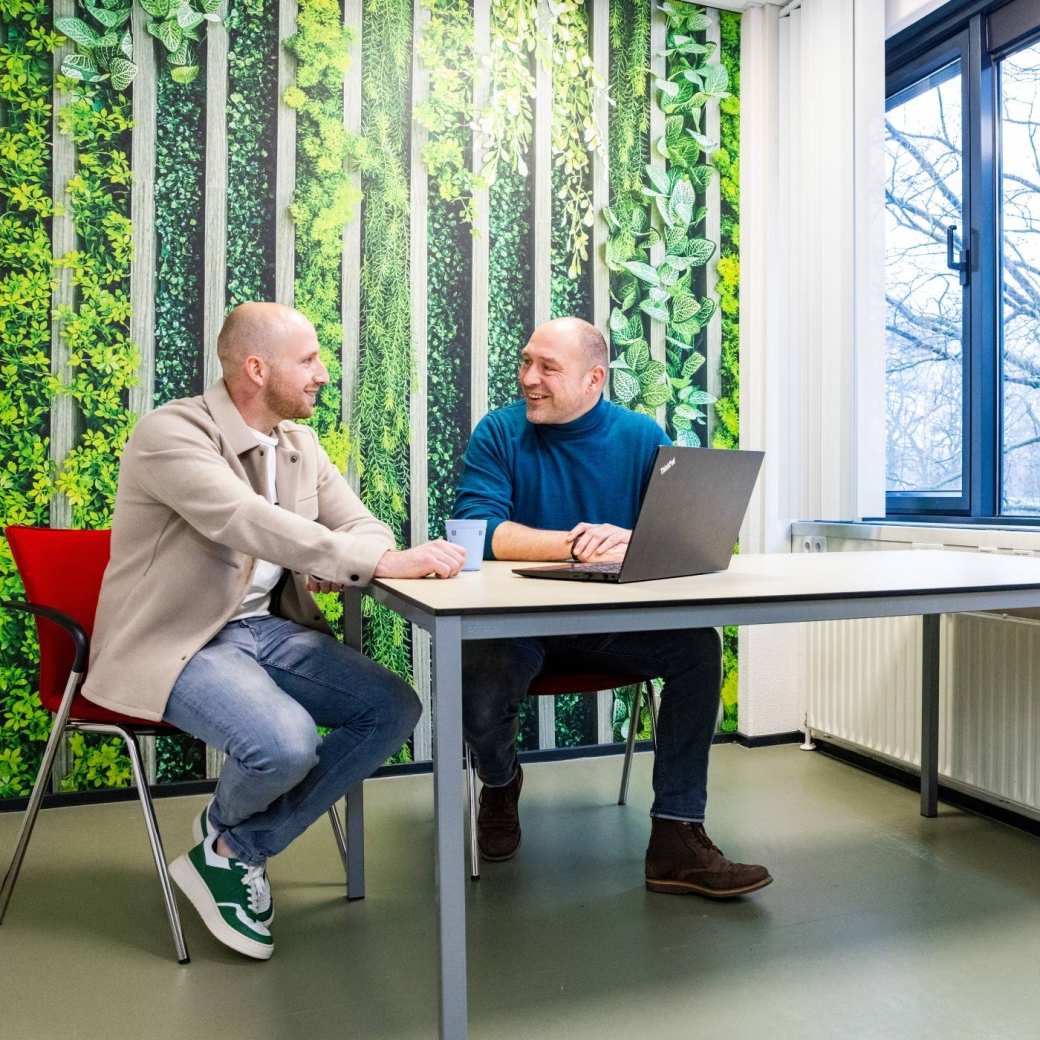 Een studieadviseur en docent heeft een gesprek met een student Bedrijfskunde deeltijd