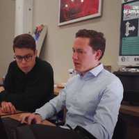 Elektrotechniek studenten Sam en Wouter bespreken een afstudeerproject met behulp van een computerscherm