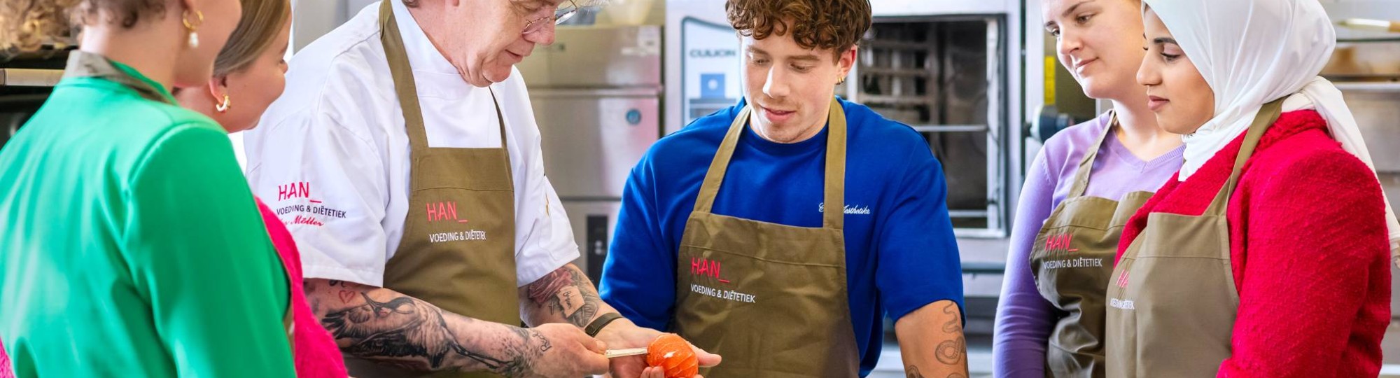 Studenten krijgen instructie in de keuken.