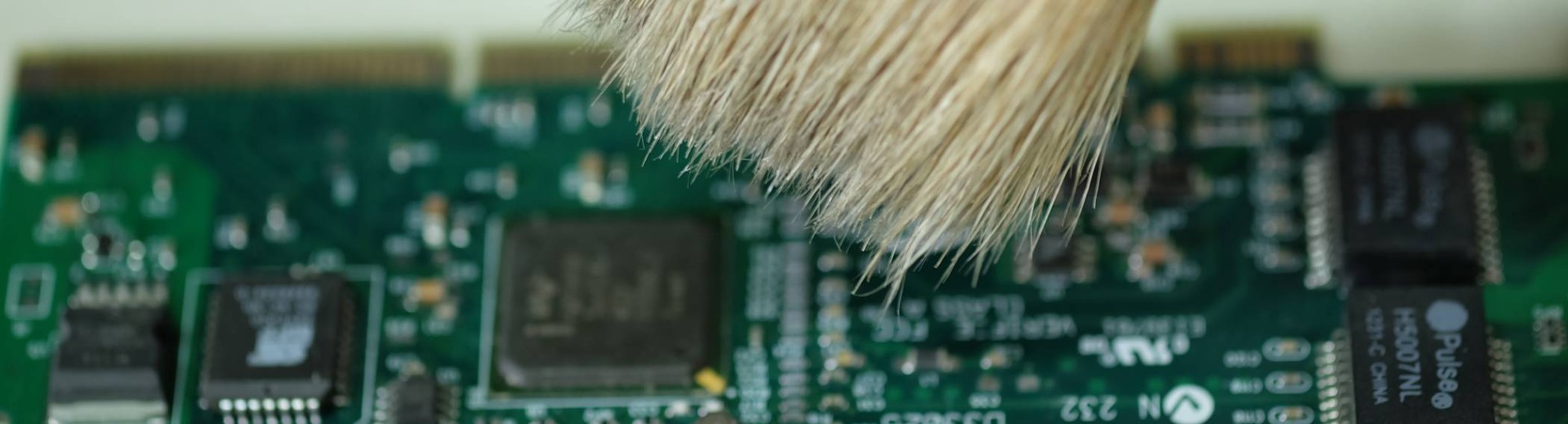 Een stuk hardware wordt schoongemaakt met een kwast.