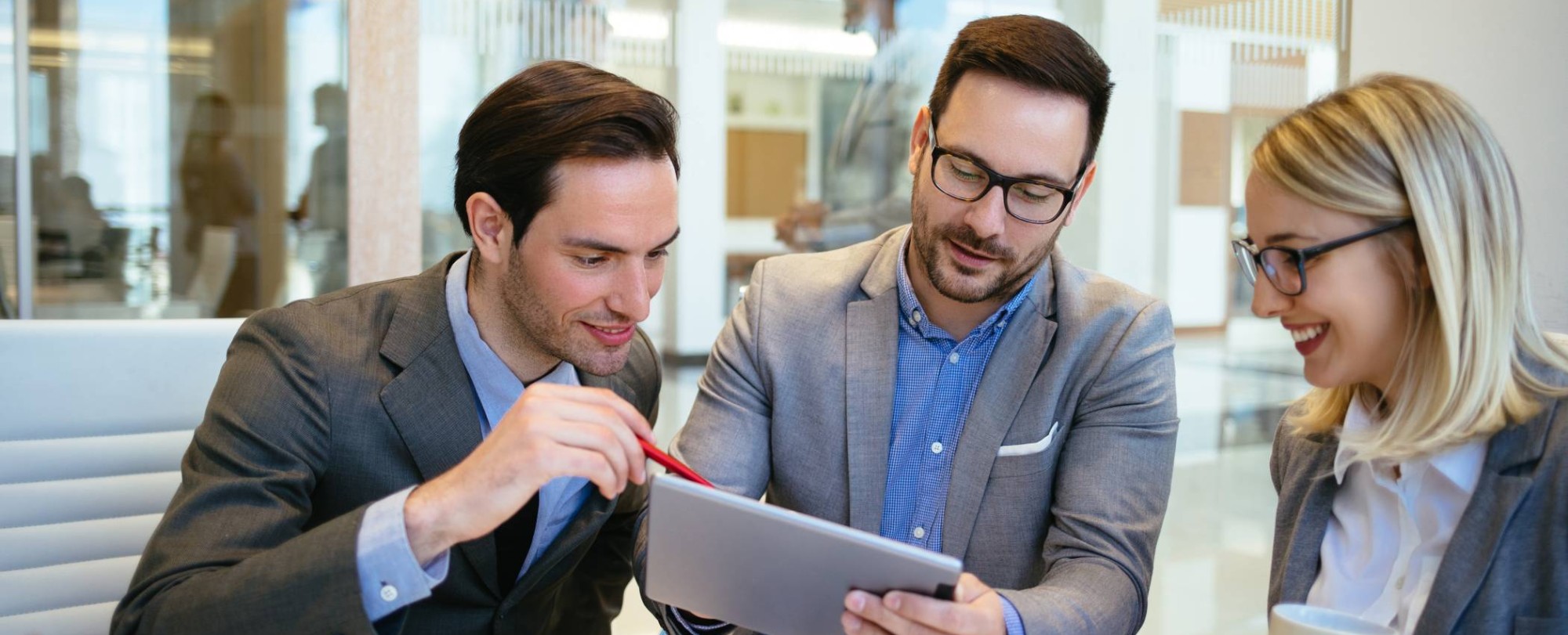 Foto van drie mensen in overleg met tablet in de hand voor projectpagina Associate lectoraat Sustainable Finance & Tax