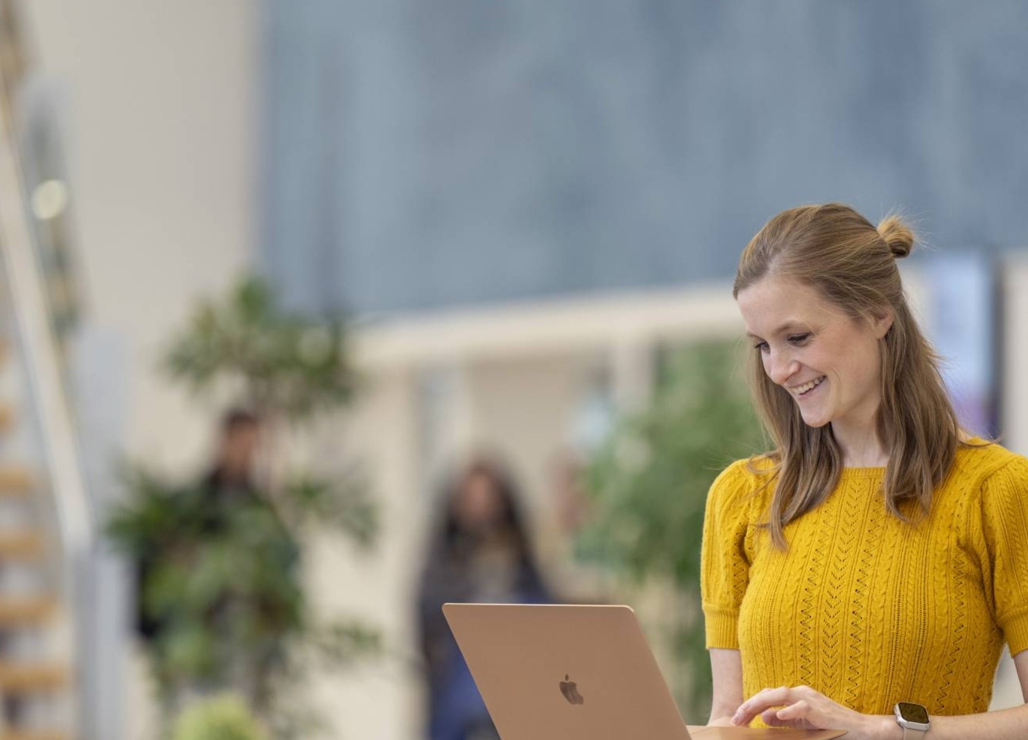 Deeltijdstudent checkt iets op haar laptop in de hal.