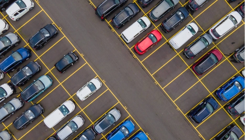 Bovenaanzicht van grote partij auto's die op een parkeerplaats klaarstaan om ete verschepen.