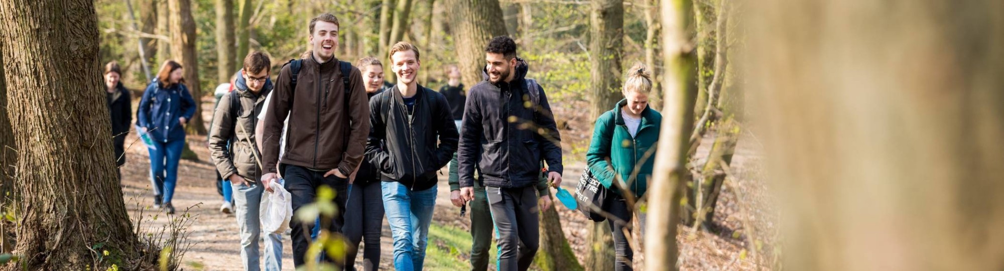 Groep biologie studenten lachend in het bos