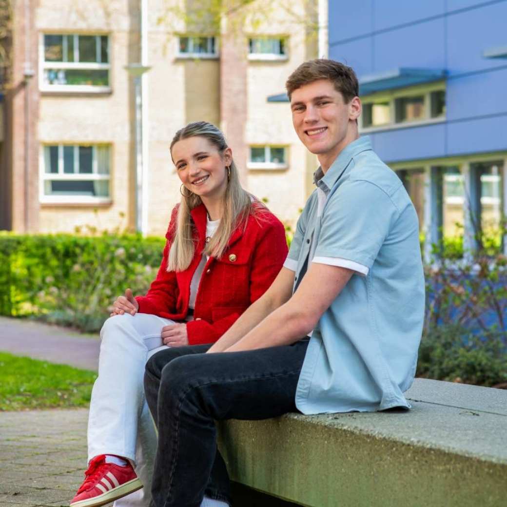 Twee studenten HRM zitten op een bankje op de HAN campus in Nijmegen