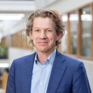 Jos Sanders, werkzaam bij lectoraat Leren tijdens de loopbaan. lichte blauwe blouse, kobalt blauw jasje