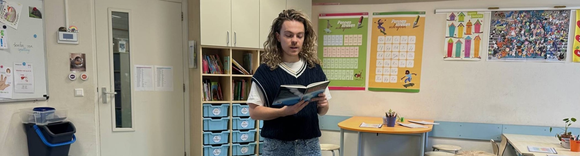 Leerkracht Freek Wouters leest een boek voor aan een aantal leerlingen van groep 3-4