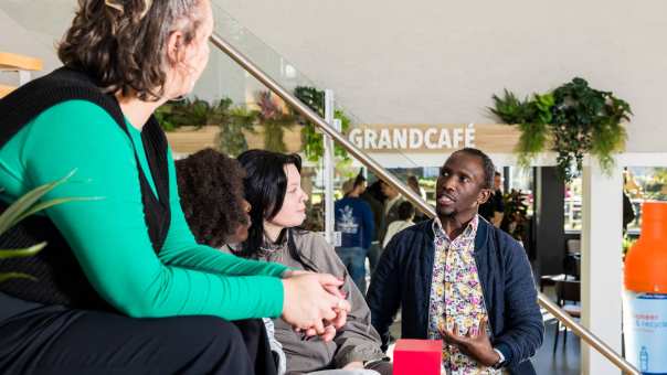 Een docent legt iets uit aan een klas met studenten International Social Work.