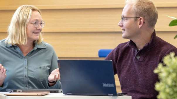 Twee HR-masterstudenten overleggen met elkaar bij een laptop.