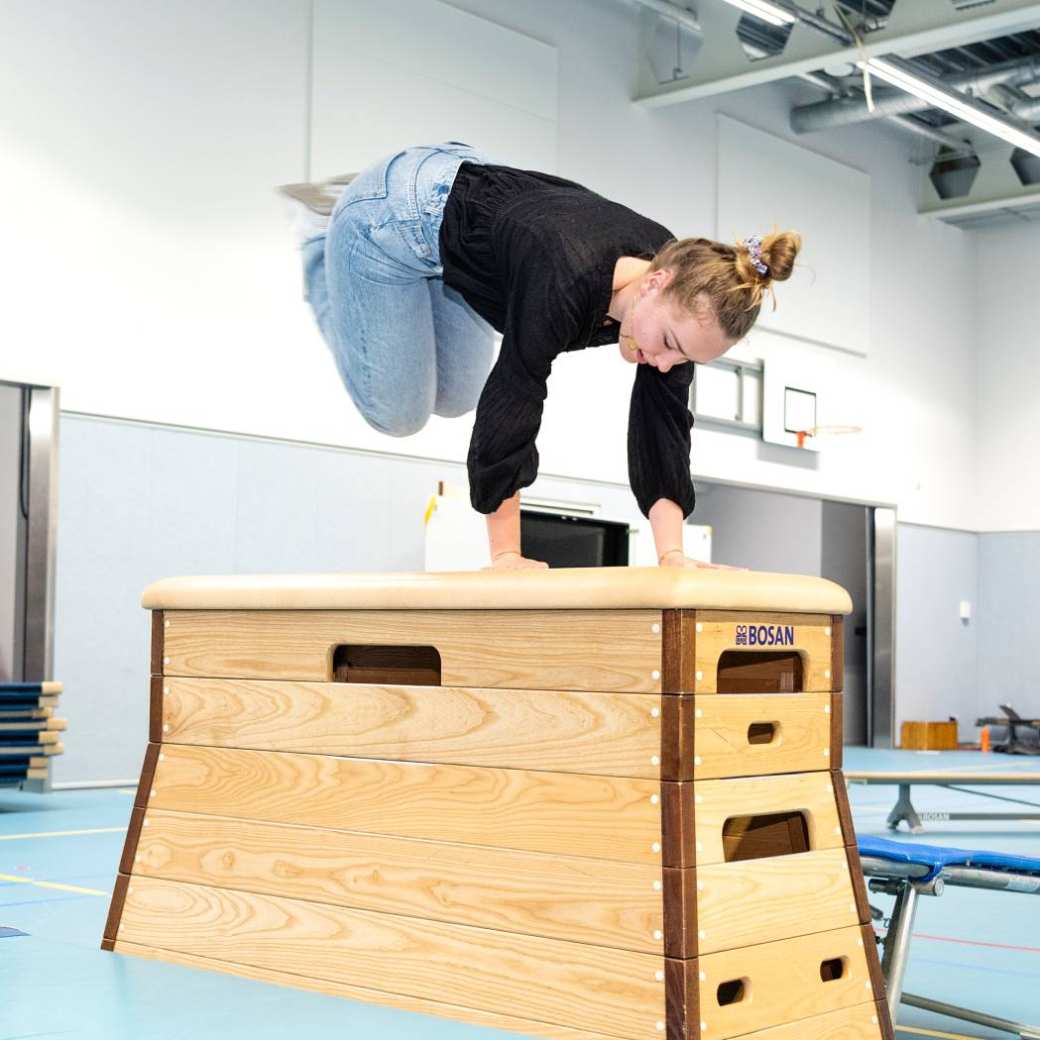 Student PMT springt over de bok tijdens praktijkles