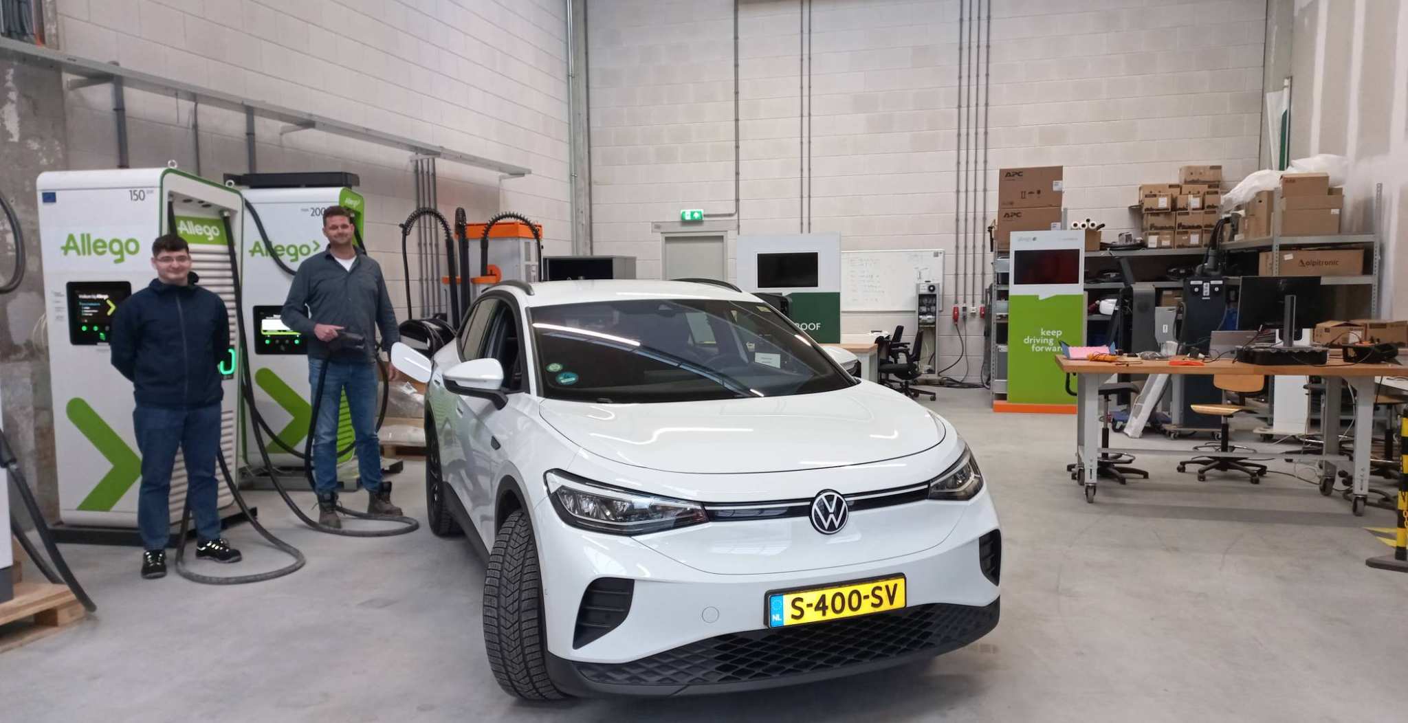 Student Alexe met begeleider Marco bij laadopstelling van Allego