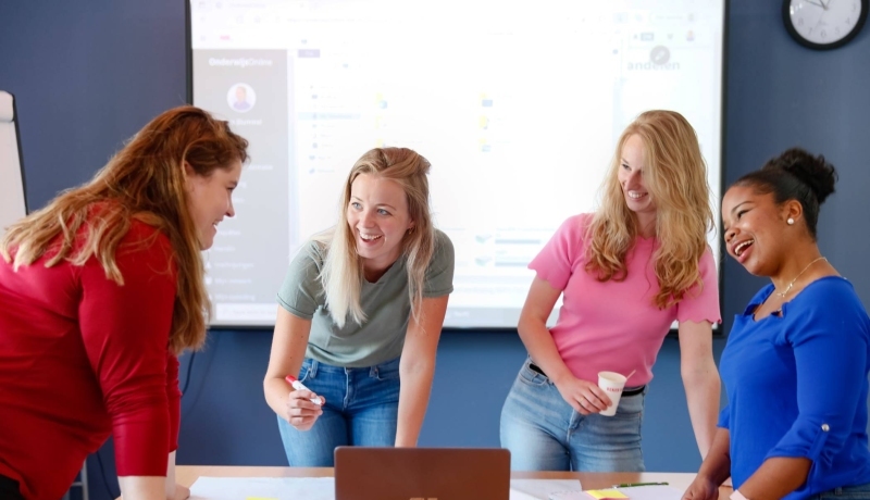 Studenten aan tafel en voeren projectoverleg met flipover vel