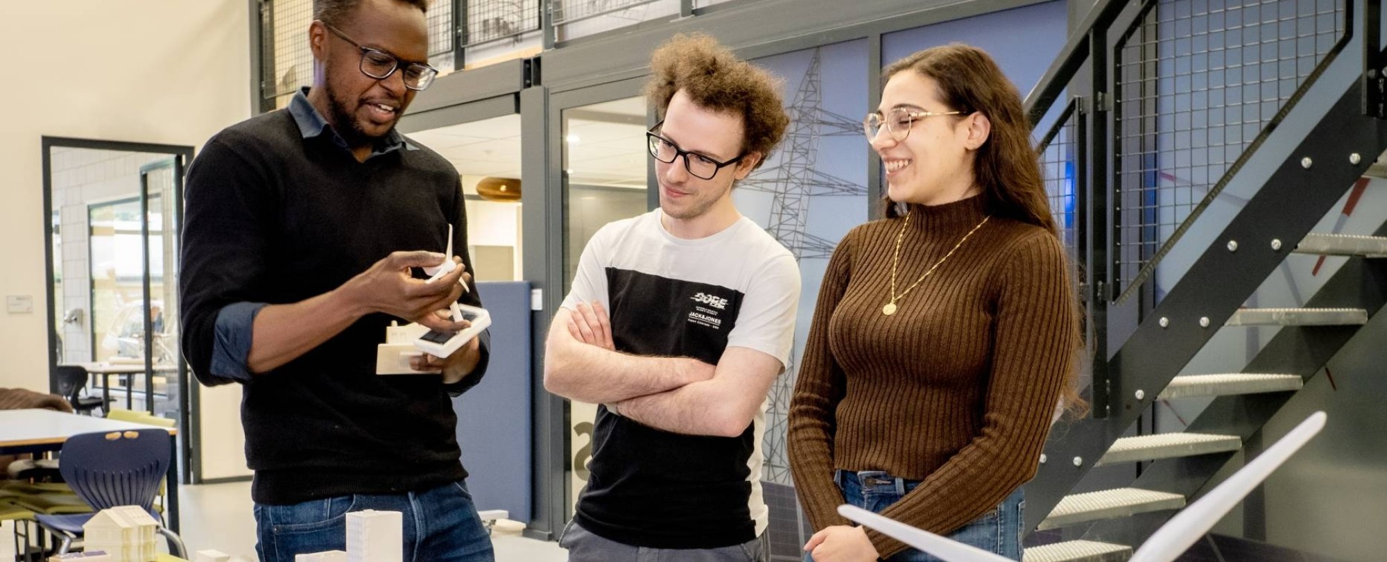 2 cursisten Energietransitie praten bij de Smart Grid demotafel met een docent.