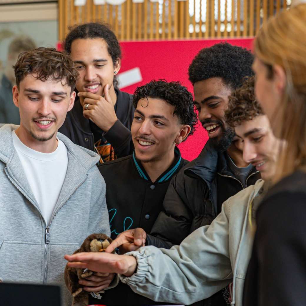 Foto van meerdere studenten die in gesprek zijn op een Netwerkmarkt.