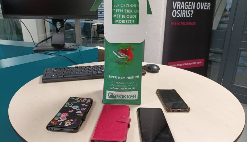 Verouderde of kapotte modellen mobieltjes leveren medewerkers van de HAN in bij stichting Opkikker. Voor hergebruik van apparaten of onderdelen.