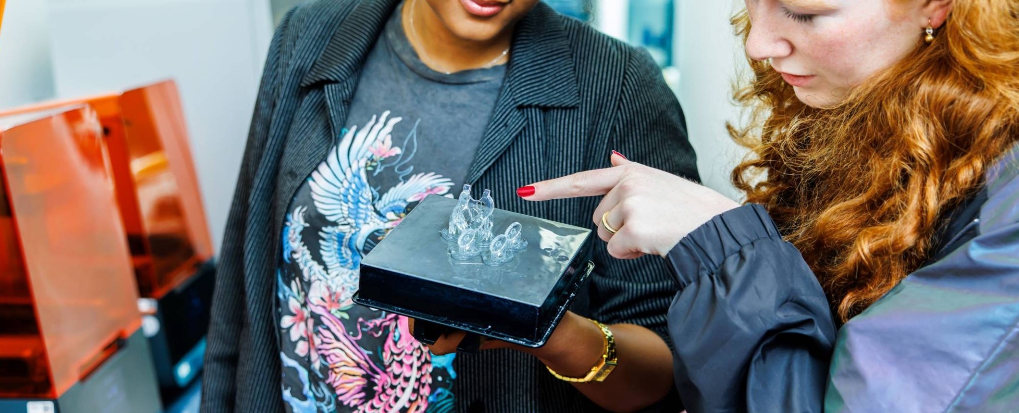 IPO-student Elena wijst naar het 3d geprinte product van student Tayisha in Fab Lab bij Industrieel Product Ontwerpen
