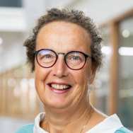 Portretfoto Marian de van der Schueren, brildragend, witte blouse, zeegroene trui