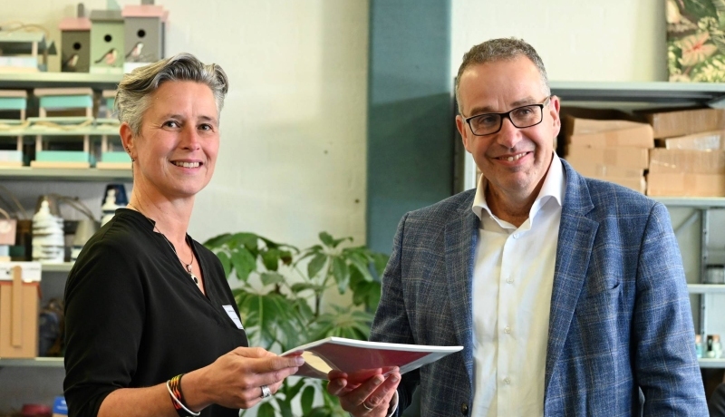 HAN onderzoeker Carinda Jansen overhandigt de gids behorend bij onderzoek Signaleren, bespreekbaar maken en doorbreken van armoede aan wethouder Aart Slob van Gemeente Lingewaard.