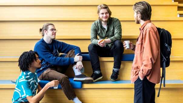docent Vyasa groet CMD-studenten op de trap in de centrale hal