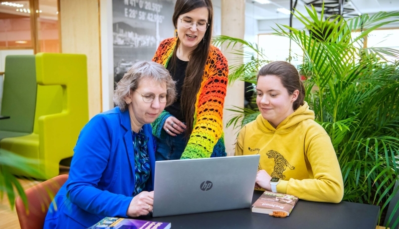 Foto Master Academie Educatie. 3 masterstudenten werken samen en kijken op een laptop.