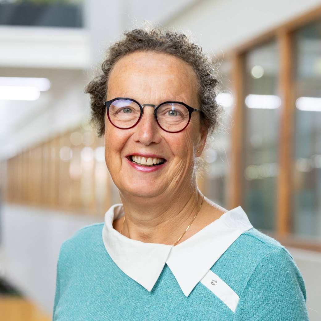 Portretfoto Marian de van der Schueren, brildragend, witte blouse, zeegroene trui
