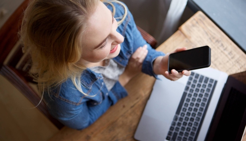 Stockfoto van vrouw met laptop en telefoon voor website Centrum Meervoudige Waardecreatie.