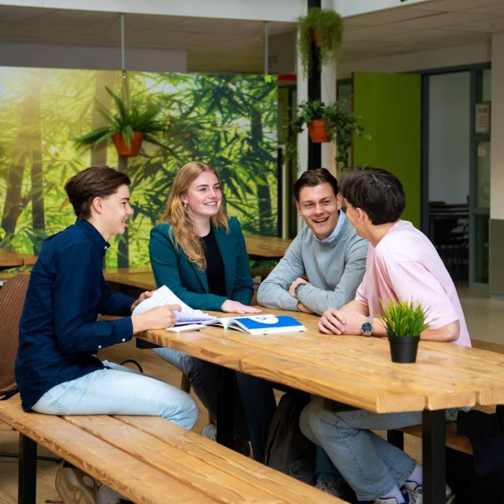 Studenten hbo Facility Management kletsen aan een tafel