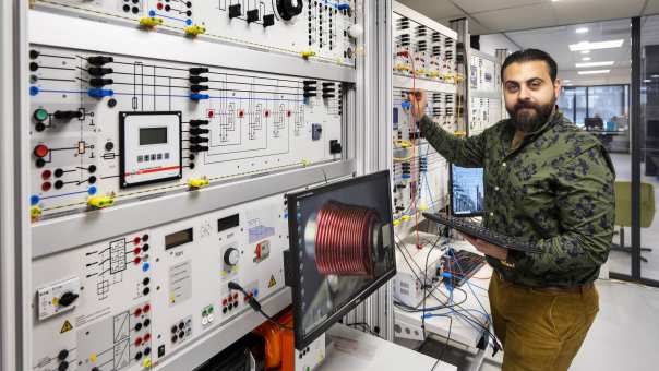 Orwa Al Bitar bij de knoppenkast.SEECE, SEE, HAN WATTS, Powerminor, deeltijd Elektrotechniek, Lectoraat Meet- en Regeltechniek, Lectoraat Duurzame Energie, Lectoraat Balanced Energy Systems.