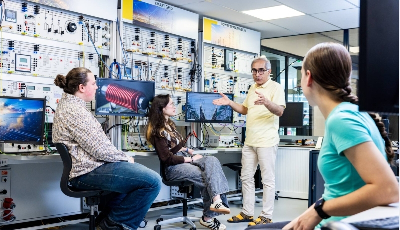 Studenten en docent elektrotechniek tijdens een les in het hoogspanningslab.