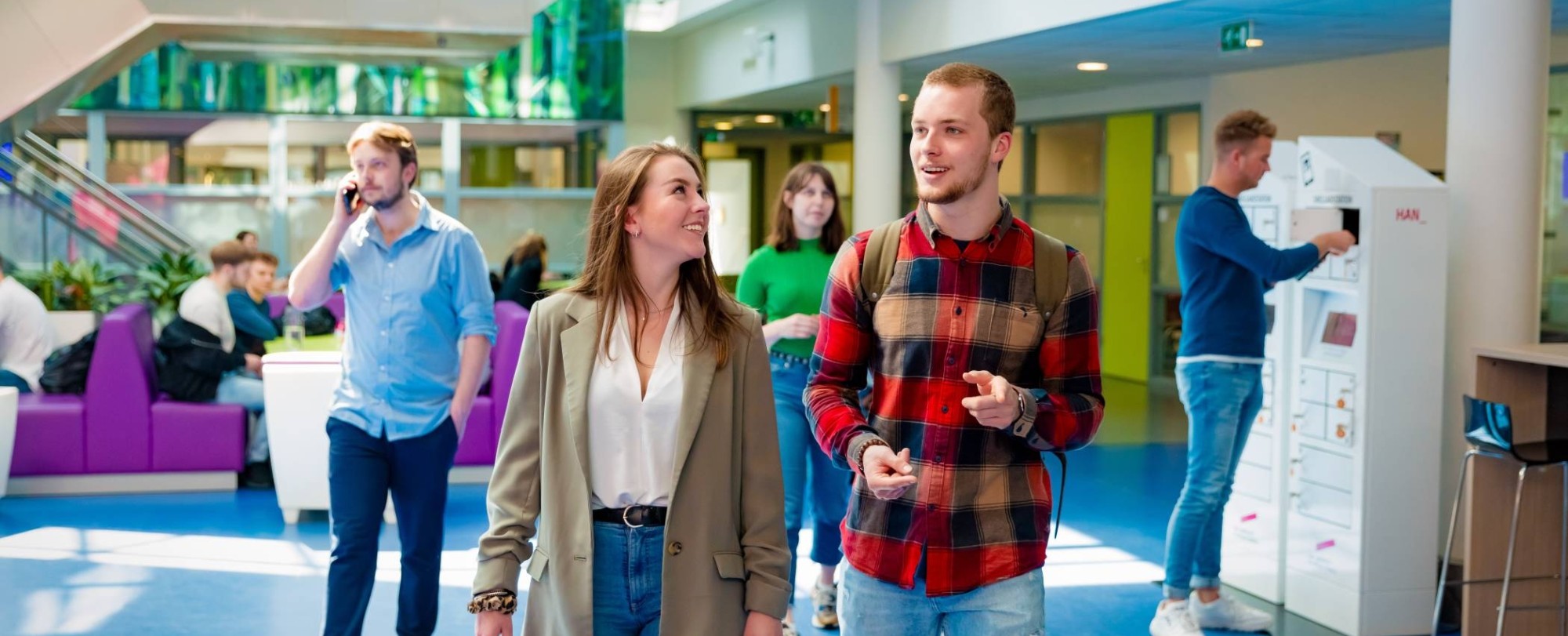 studenten van learning and development lopen door de gang in de HAN campus