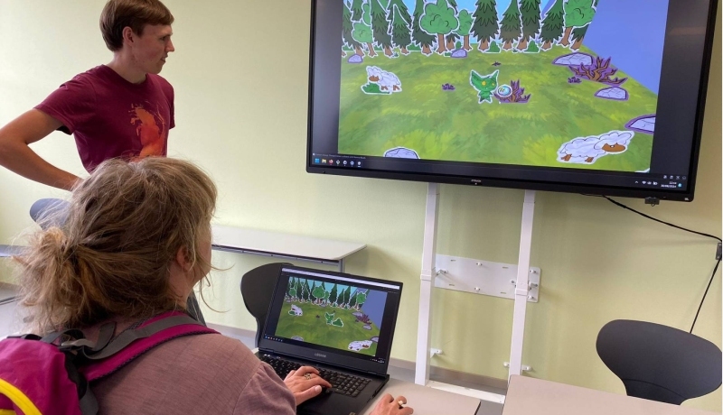 Student achter een laptop maakt een game