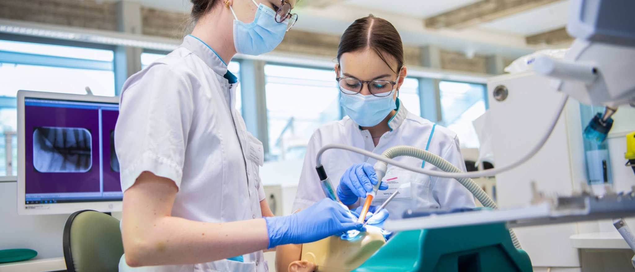 2 studenten voeren een behandeling uit op een patient.