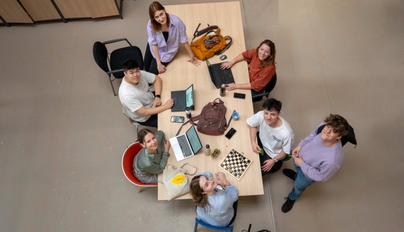 studenten in collegezaal laptop en boeken nodig