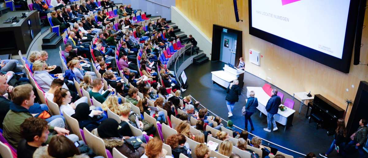 van bovenaf in auditorium met volle zaal voor presentatie