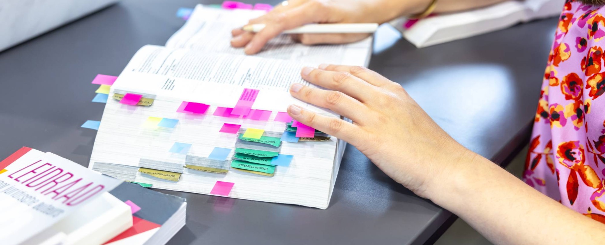 Vingers bladeren door een wettenbundel 