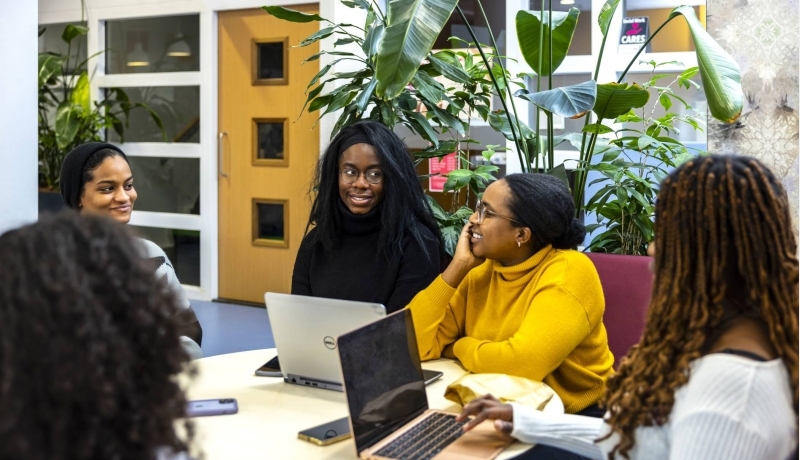 4 studenten master International Social Work overleggen met elkaar aan een tafel.