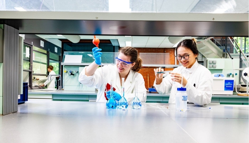 studenten pipetteren in het chemielab