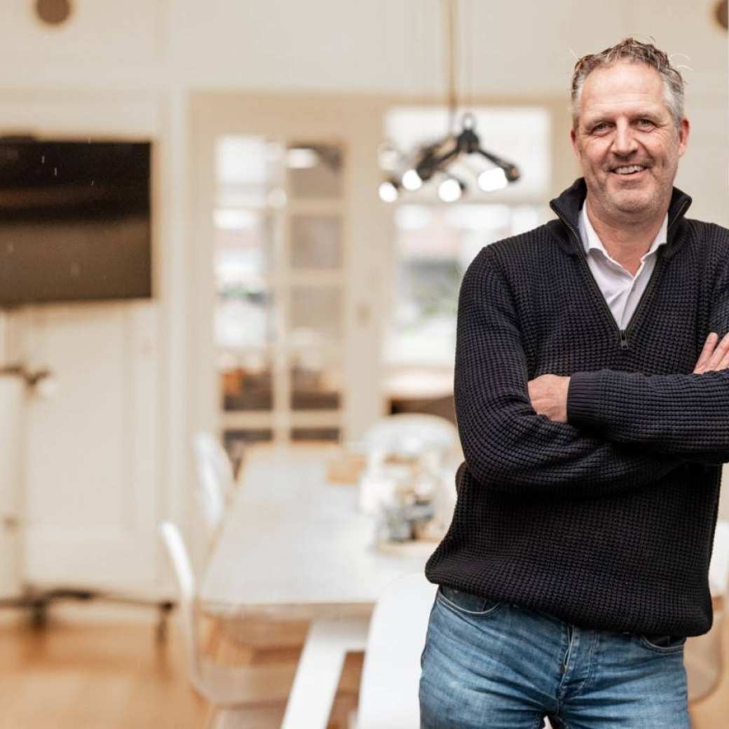 Ad Pompen leunt tegen de deurstijl